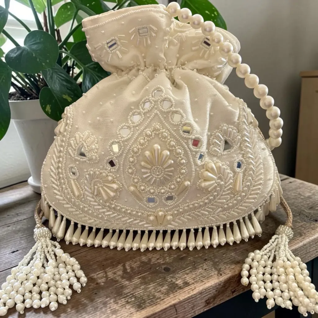 beige pearl beaded wedding potli with a pearl handle.